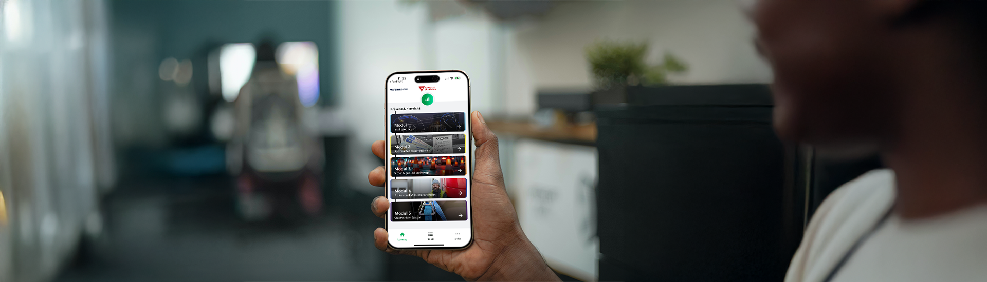 Junge Person hält Smartphone in der Hand und hat die Startseite der Vogel BKF App geöffnet