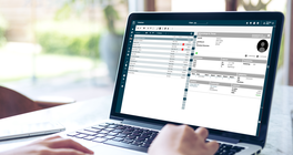 Hände tippen auf Laptop mit Screen vom Fahrschul-Manager