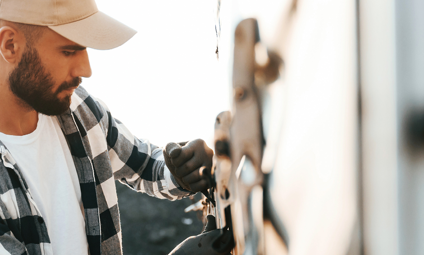 Junger Mann befestigt LKW-Plane an Lkw