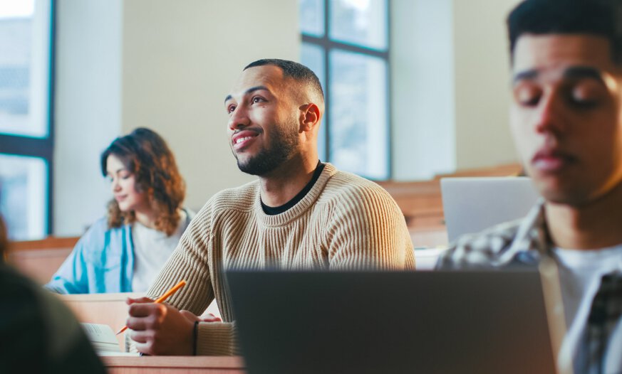 Junger Mann sitzt im Hörsaal