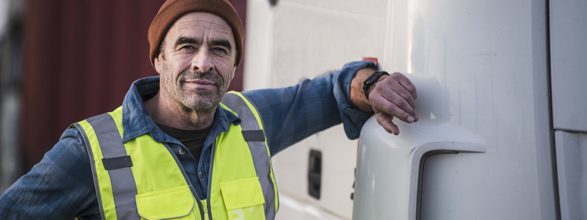 Lehr- udn Lernmedien für die Weiterbildung älterer Mann steht an Lkw mit Hand am Fahrzeug