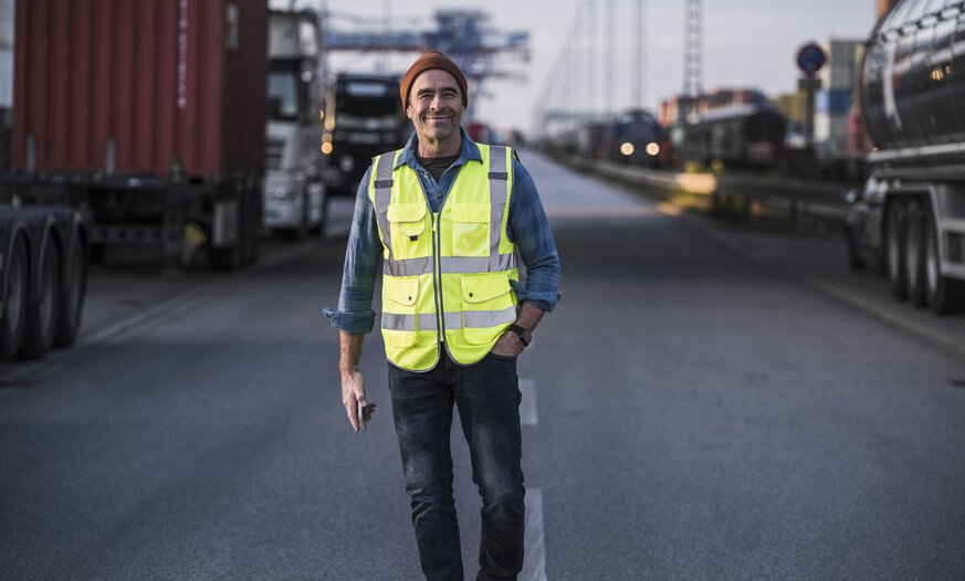 Mann steht an Lkw mit Hand auf der Motorhaube