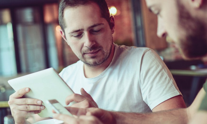 News und Produktinfos aus der Berufskraftfahrerbranche Männer sitzen in Café mit Tablet