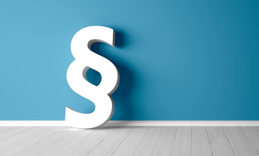 Weißes dreidimensionales Paragraphenzeichen vor blauem Hintergrund