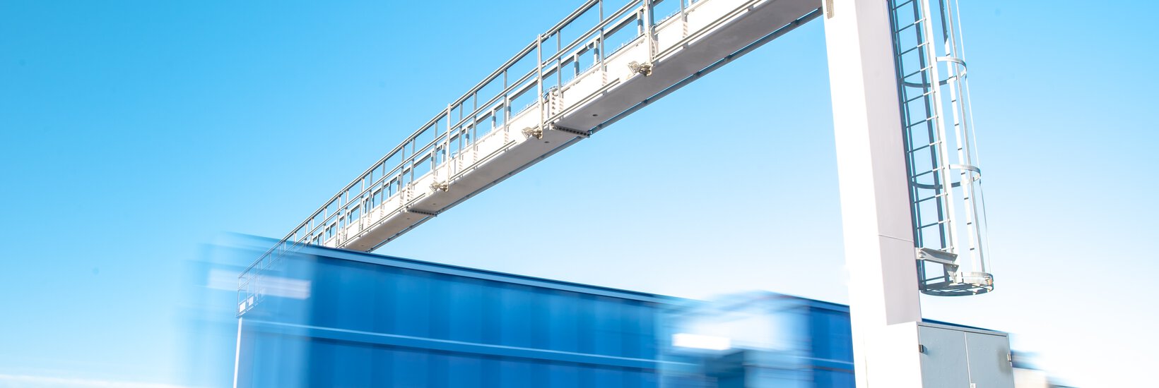 Lkw fährt durch Zollbrücke Blauer Lkw fährt auf Autobahn durch eine Zollbrücke