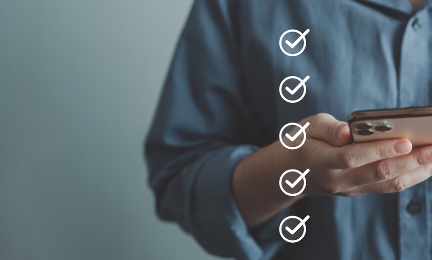 Lösungen zum Quali-Quiz und den Prüfungsfragen zur BKF-Ausbildung Weiße Checkliste. Frau mit Smartphone im Hintergrund