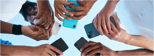 Junge Männer stehen im Kreis mit Smartphones in den Händen