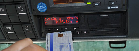 Hand steckt Fahrerkarte in das digitale Kontrollgerät