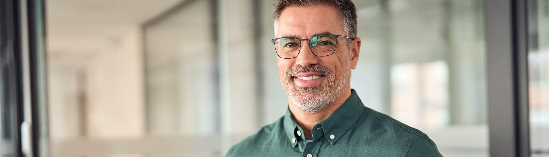 Freundlicher Mann im legeren Hemd vor Glastür