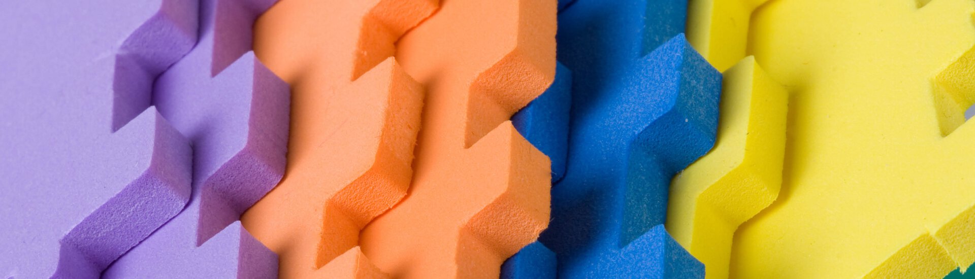 Detailaufnahme von Schaumstoffmatten die aussehen wie Puzzleteile in vier verschiedenen Farben Bunte Schaumstoffmatten in Puzzleoptik