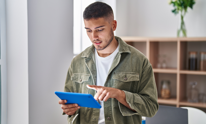 Junger konzentrierter Mann mit Tablet
