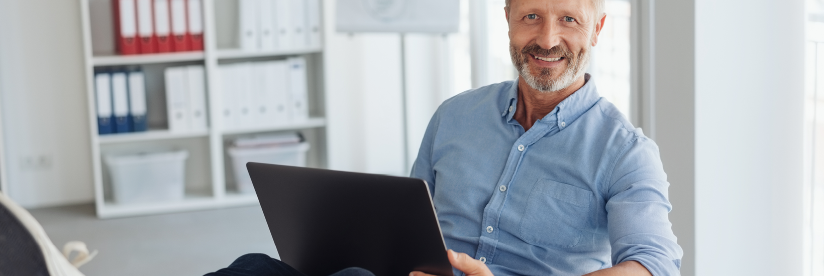 Mann mit Laptop auf dem Schoß