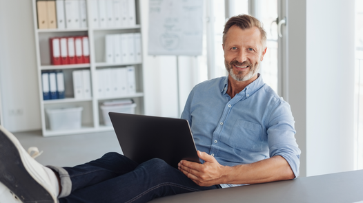 Mann mit Laptop auf dem Schoß